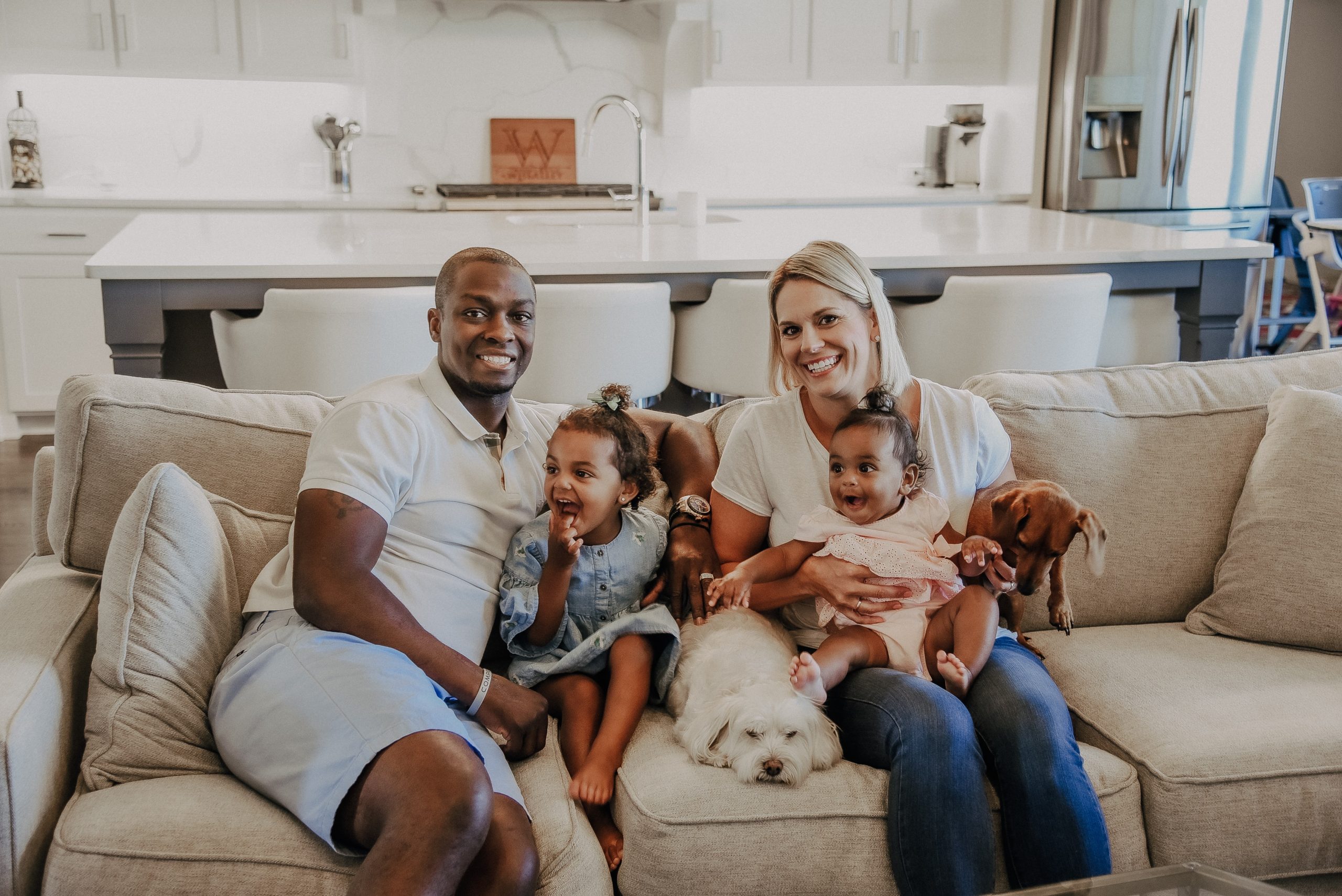 A photo of Terrence Wheatley sitting on the couch with his wife and children.